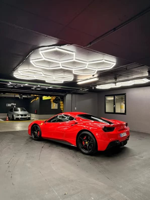 Roter Ferrari unter der Hexagon-Beleuchtung im Aufbereitungsstudio